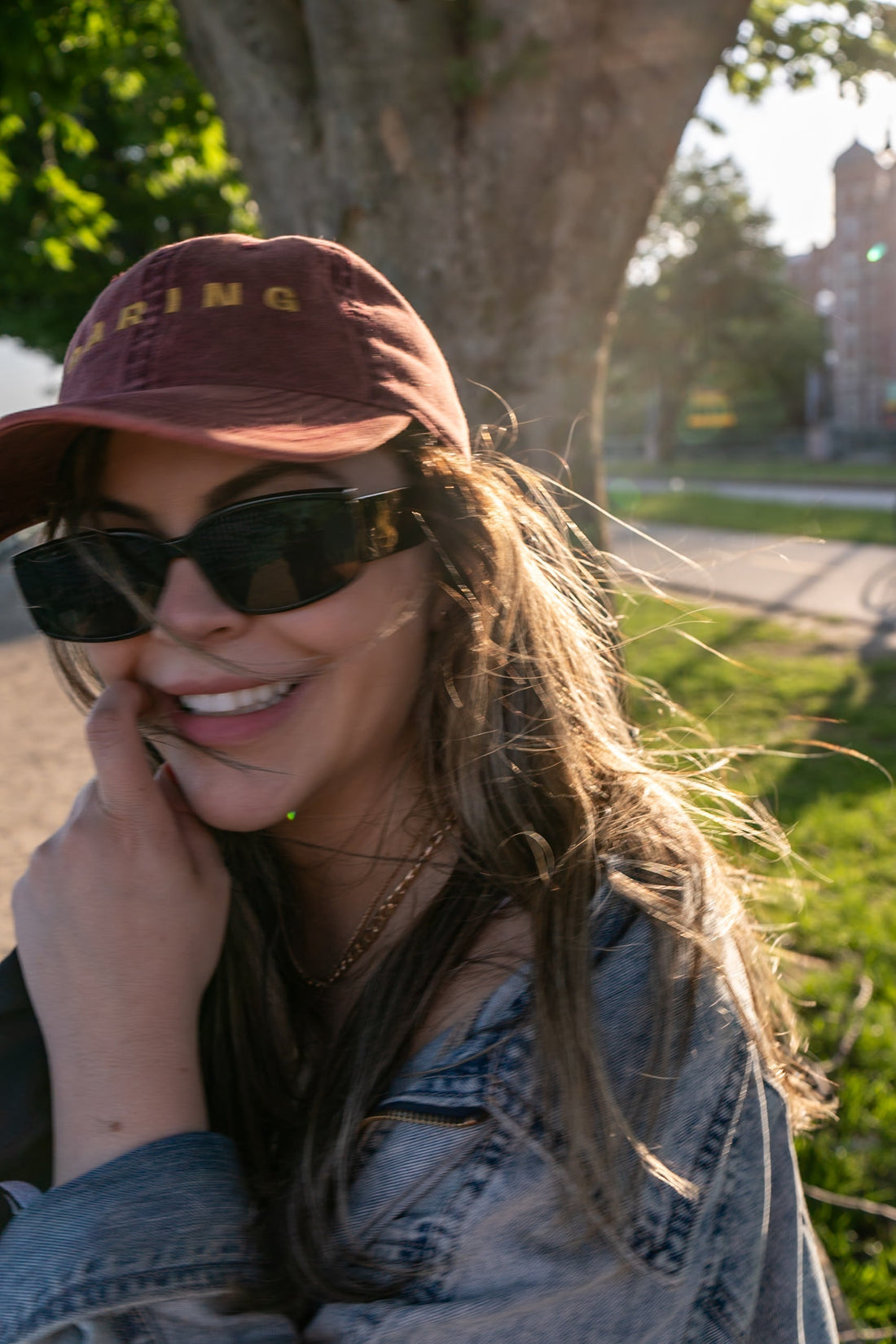 Iohana Lobo in a maroon Daring cap and sunglasses, golden hour portrait