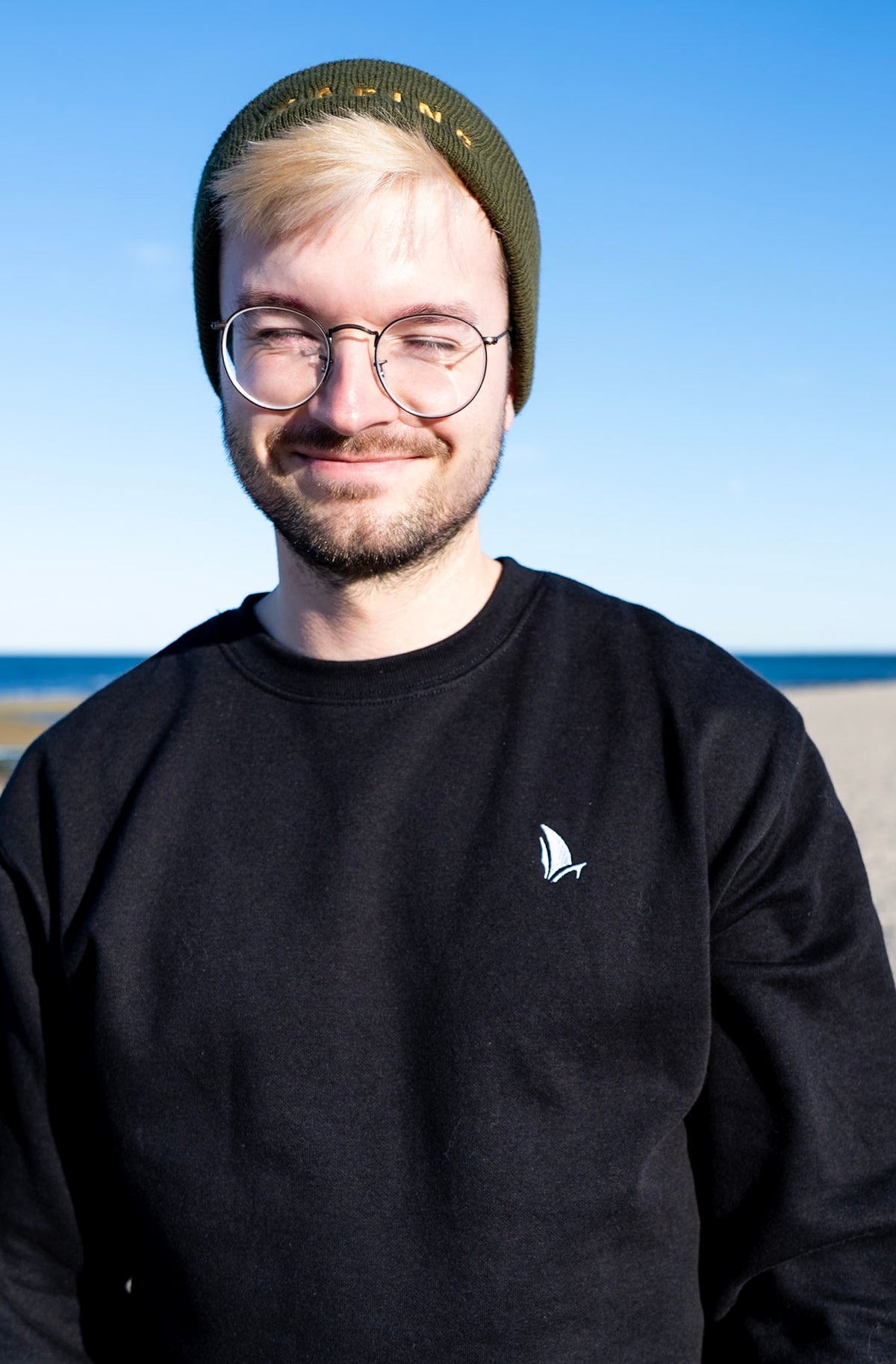 Classic Sailer Crewneck Sweatshirt in black, close-up of white sailboat embroidery