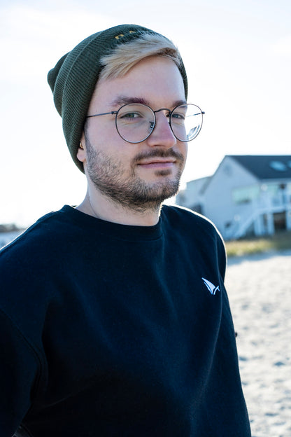 Classic Sailer Crewneck Sweatshirt in black, standing portrait on the beach